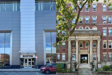 A modern glass building beside an ornate columned building on Commonwealth Avenue